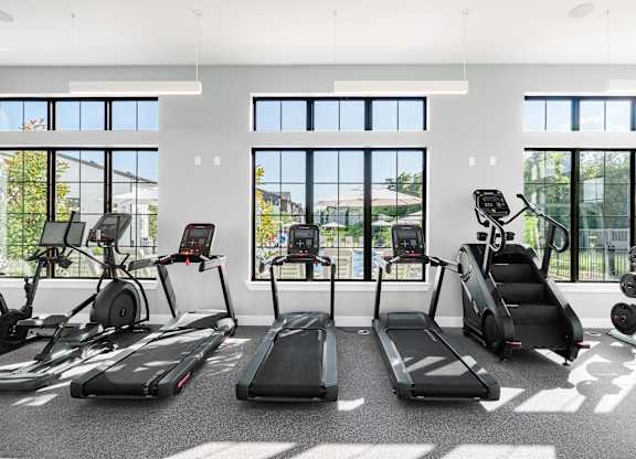 A gym with treadmills, elliptical machines, and a rowing machine.