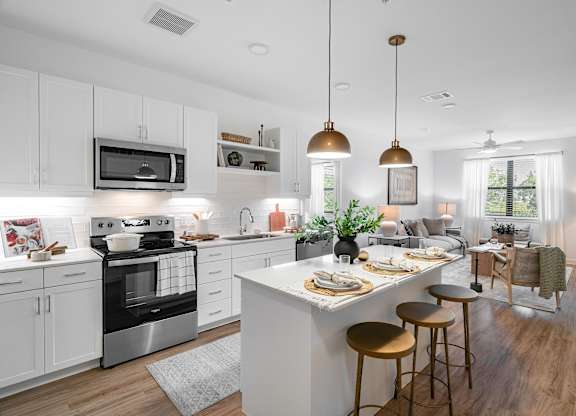 A modern kitchen with a large island and bar stools.