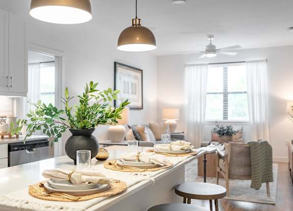 A modern kitchen with a dining table set for two.