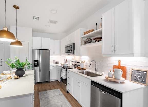 A kitchen with white cabinets and a black dishwasher.