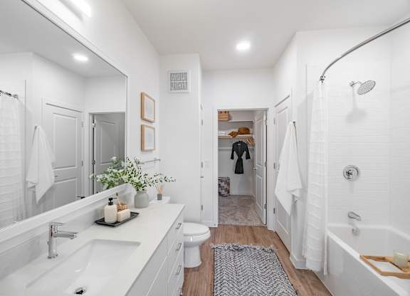 A white bathroom with a white tub and sink.