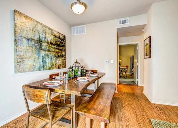 a dining room with a table and chairs and a painting on the wall at Villa Espada Apartments, Texas