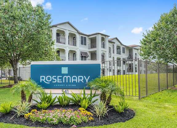 A sign for Rosemary Luxury Living in front of a building at Rosemary Apartments, Conroe, TX, 77384