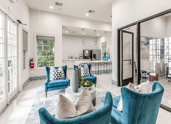 A living room with blue chairs and a white couch at Rosemary Apartments, Conroe, TX