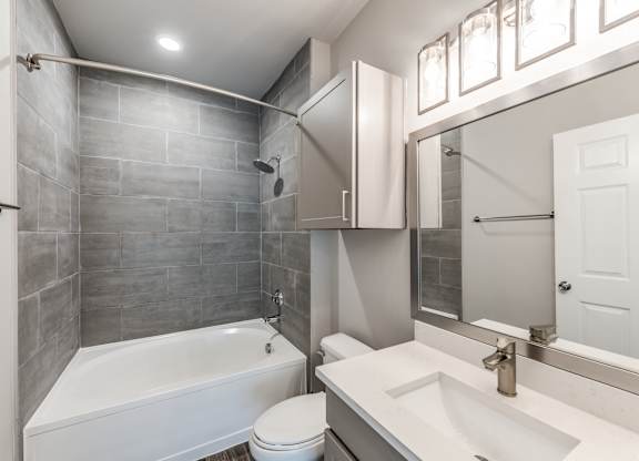 A bathroom with a white tub, sink, and toilet at Rosemary Apartments, Texas, 77384