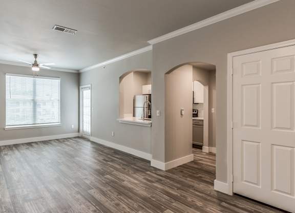 A spacious room with wooden flooring and a white door at Rosemary Apartments, Conroe, TX, 77384