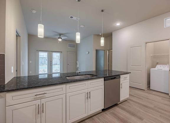 Modern kitchen with dark granite countertops at Emilia Apartments, Boerne