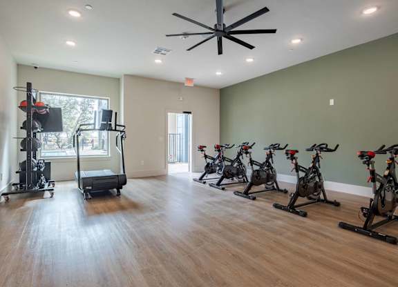 Fitness center with spin bikes and equipment at Emilia Apartments, Texas