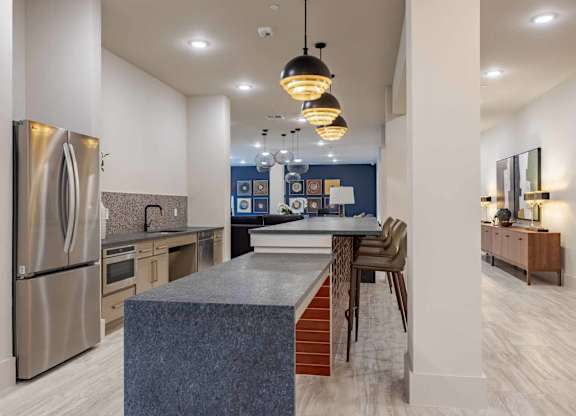 Community kitchen with blue granite island seating at Emilia Apartments, Boerne, Texas