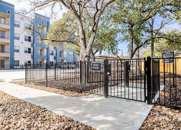 Fenced dog park with entry gate at Emilia Apartments, Boerne