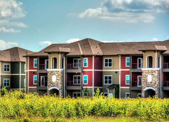 a row of apartment buildings with blue sky in the background at Villa Espada Apartments, San Antonio, TX