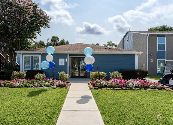 A house with a blue and white balloon arch in front of it.