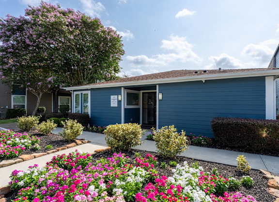 A blue building with a garden in front.