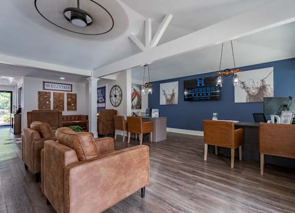 A living room with brown leather chairs and a wooden table.