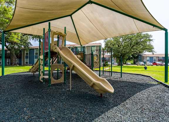 A playground with a slide and a canopy.