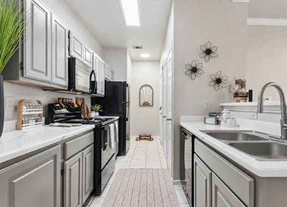 A kitchen with black appliances and white countertops.