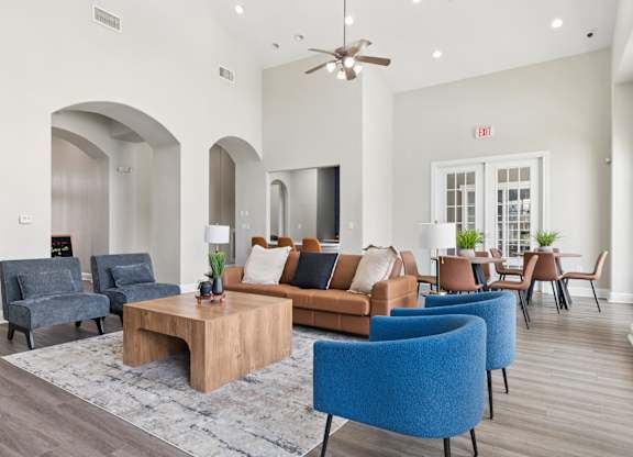 A living room with a blue chair and a brown couch.