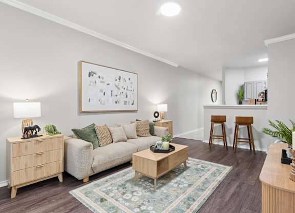A living room with a couch, a coffee table, and a painting on the wall.