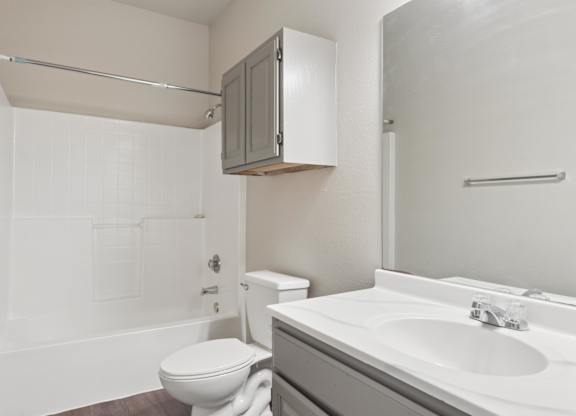 A white toilet sits next to a sink in a bathroom.