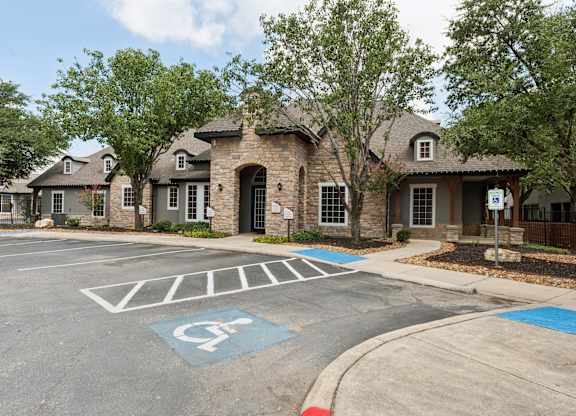 A parking lot with a handicap parking space in front of a building.