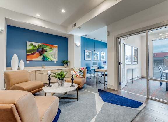 A living room with a blue accent wall and a painting of a fruit bowl.