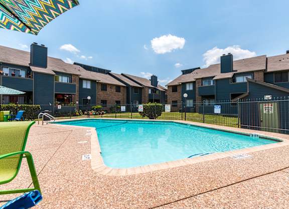 A swimming pool in front of apartment buildings.