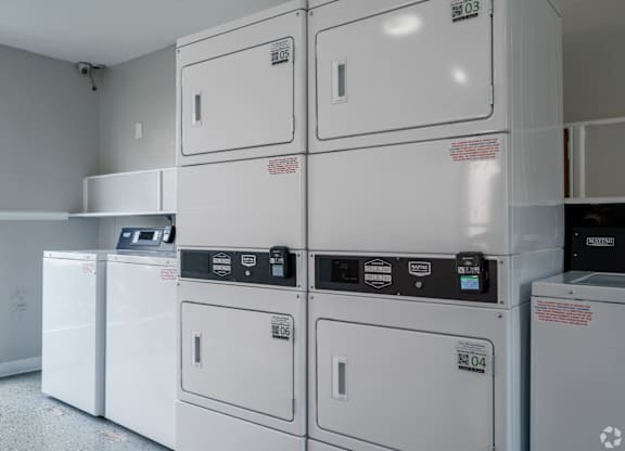 Row of white washing machines in a laundromat at Brook Meadow Village, Austin, Texas