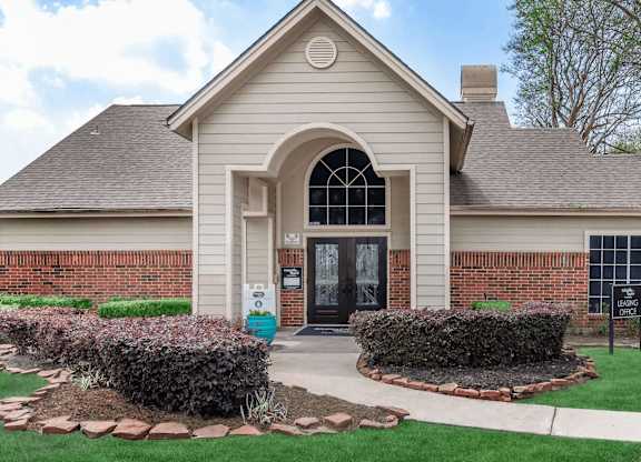the front of a house with a driveway and lawn at Tranquility Grove, Houston