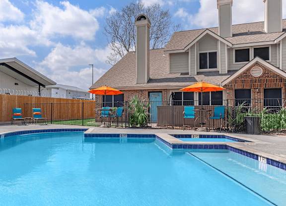 our apartments have a swimming pool with chairs and umbrellas at Tranquility Grove, Houston, 77090