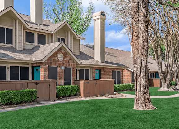 a house with a blue door and green grass at Tranquility Grove, Houston, Texas