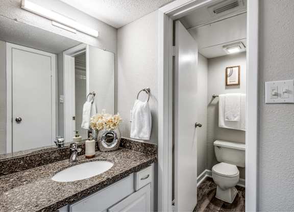 Modern bathroom with granite countertop and vanity at Monarch Medical Center Apartments, Houston