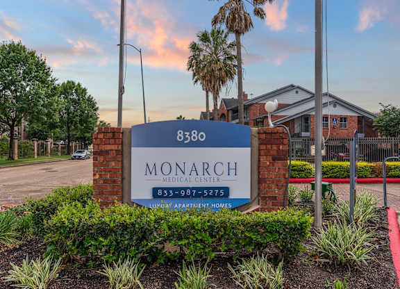 Property monument sign with brick pillars and landscaping at Monarch Medical Center Apartments, Texas