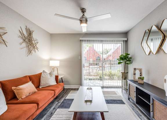 Living area with orange sofa and patio view at Monarch Medical Center Apartments, Texas, 77054
