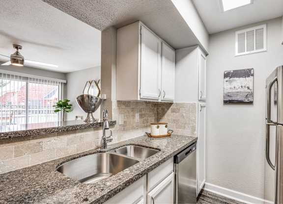 Kitchen with granite counters and double sink at Monarch Medical Center Apartments, Houston, TX