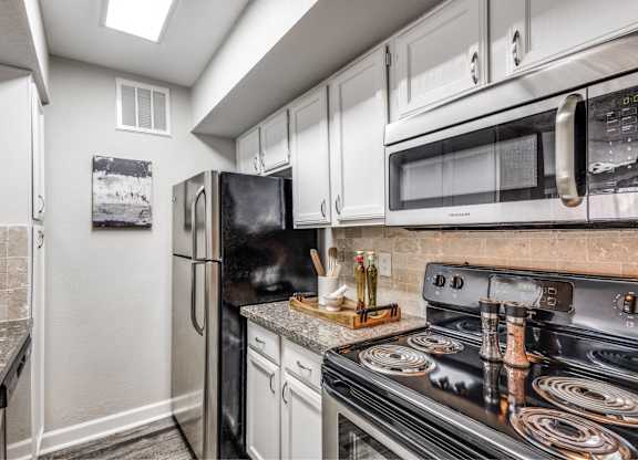 Updated kitchen with black appliances and skylight at Monarch Medical Center Apartments, Houston, Texas