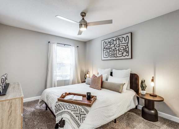 Cozy bedroom with white bedding and artwork at Monarch Medical Center Apartments, Houston