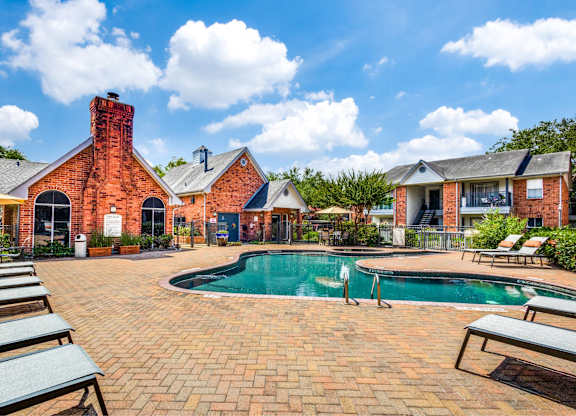 Pool area with brick clubhouse and lounge chairs at Monarch Medical Center Apartments, Texas, 77054