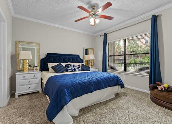 Bedroom with blue bedding and ceiling fan at Melia Medical Center Apartments, Houston, TX 77054