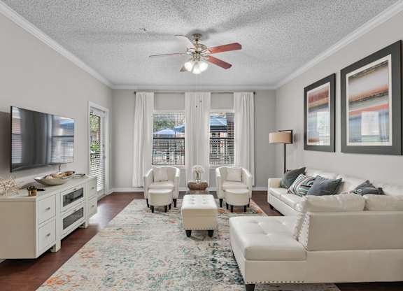 Living room with white furniture and ceiling fan at Melia Medical Center Apartments, Houston, TX