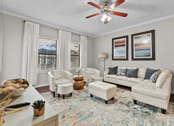 Modern living room with ceiling fan and sectional sofa at Melia Medical Center Apartments, Houston, Texas