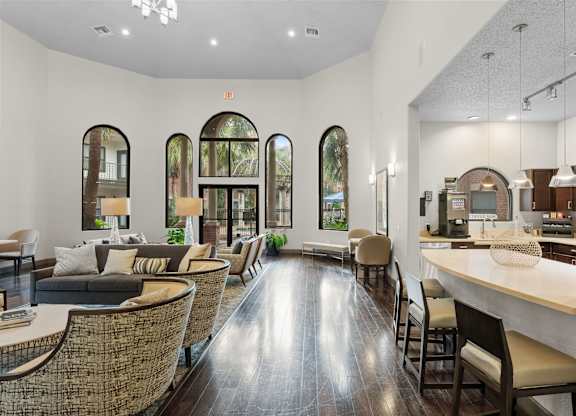 Clubhouse lounge with arched windows and kitchen area at Melia Medical Center Apartments, Houston, Texas