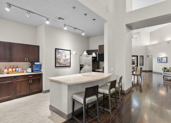 Community kitchen with island seating and wood floors at Melia Medical Center Apartments, Houston