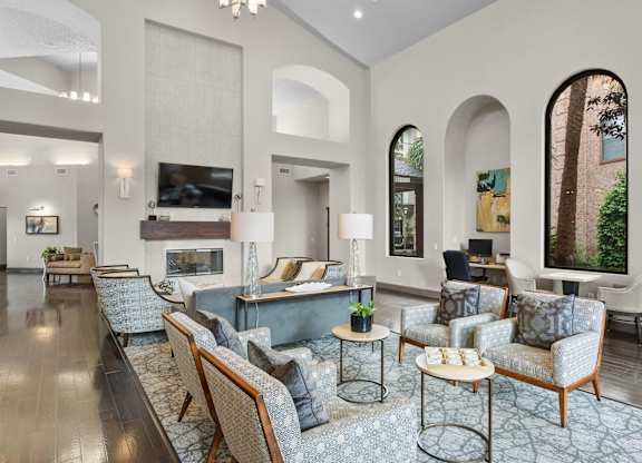 Clubhouse lounge with tall arched windows and seating at Melia Medical Center Apartments, Texas