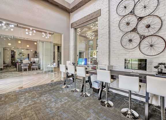 A white bar with stools is in front of a wall with bicycle decorations.