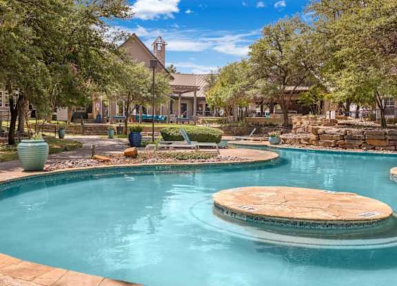 A pool with a fountain in the middle of it.
