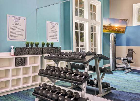 A gym with a blue wall and a sign that says "HIDDEN FITNESS".