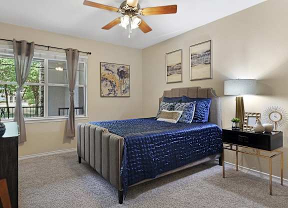 A bedroom with a bed, nightstand, and window.
