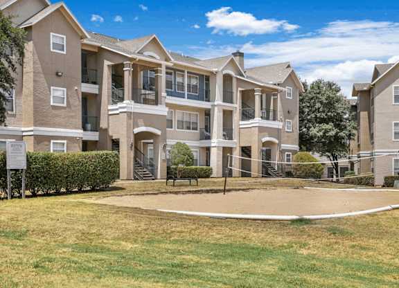 Apartment complex with a grassy area in front.