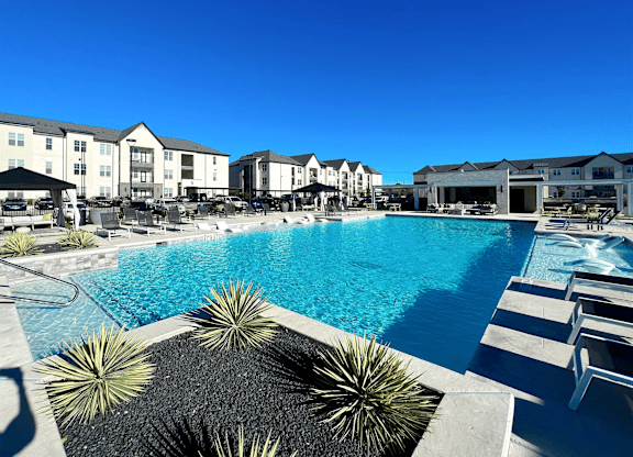 a large swimming pool with buildings in the background at The Fitzroy San Marcos, San Marcos, Texas
