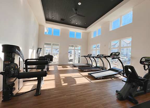a gym with cardio equipment and windows in a building at The Fitzroy San Marcos, Texas